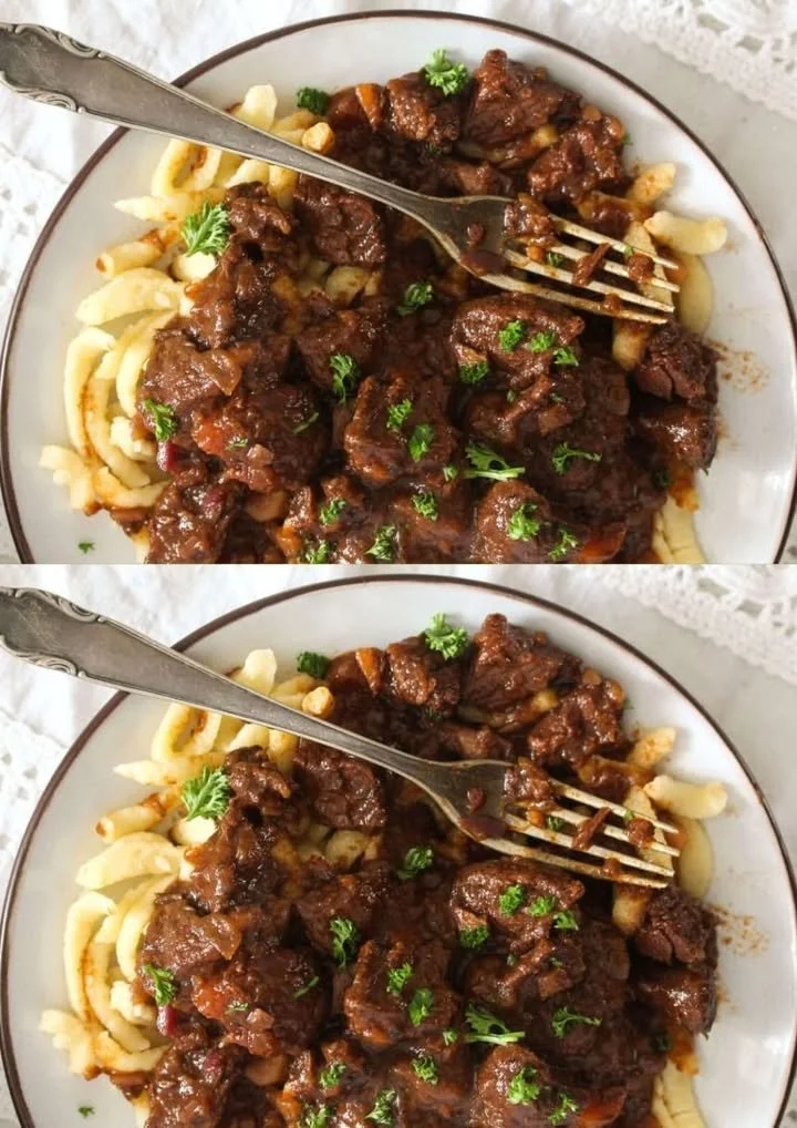 Heerlijke Duitse Goulash geserveerd met verse kruiden en brood.