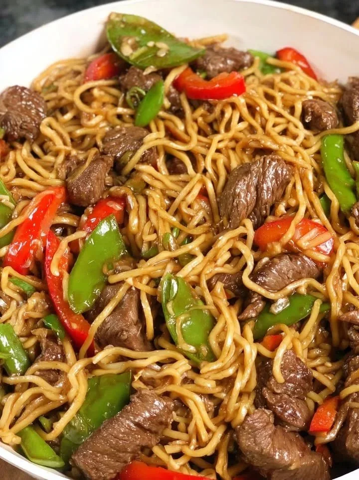 Spetterende knoflook-sojabeef geserveerd met noedels en krokante groenten