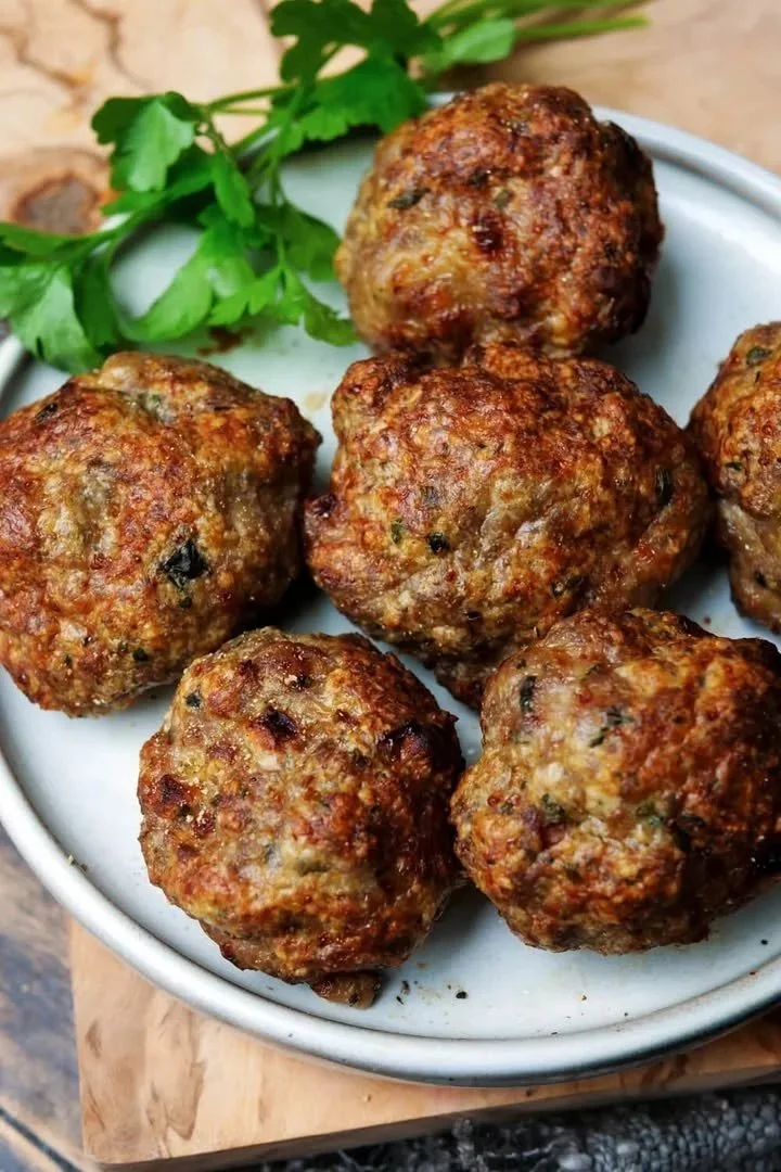 Vleeskroketten bereid in de Airfryer, goudbruin en krokant op een bord.