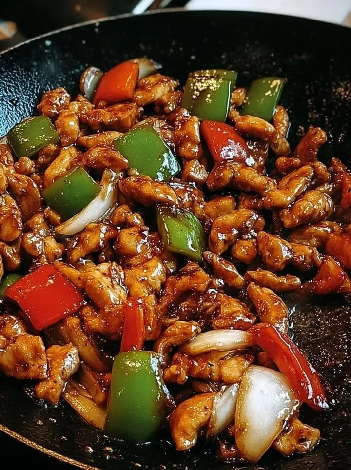 Wokgebakken kip met zwarte peper, paprika en gekaramelliseerde uien gerecht