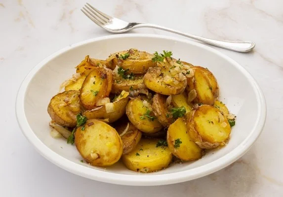 Recept voor gebakken aardappelen, knapperig en lekker, geserveerd met kruiden.