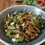 Pittige rijstnoedelsalade met kleurrijke groenten en kruiden.