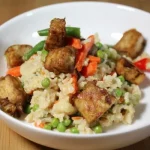 Rijstpan met knapperige tofu en verse groente in een kleurrijk gerecht