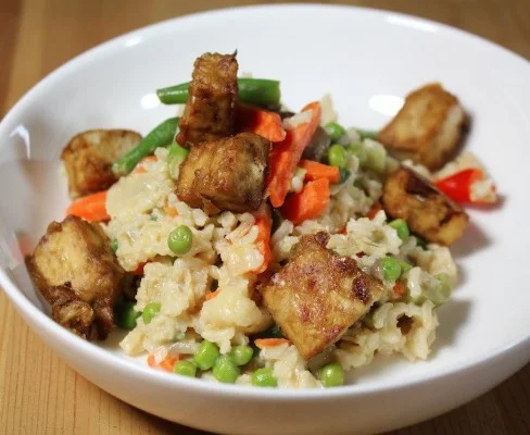 Rijstpan met knapperige tofu en verse groente in een kleurrijk gerecht