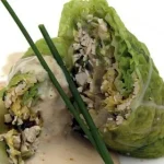 Savooiekoolrolletjes gevuld met gerookte tempeh en geserveerd met mosterdsaus.