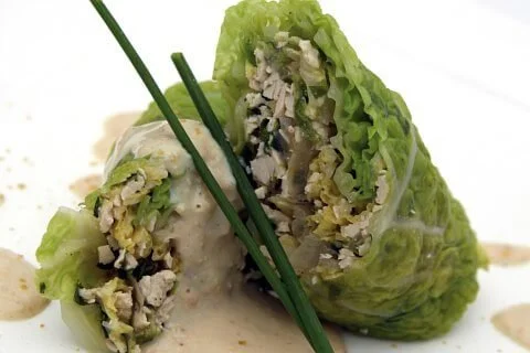 Savooiekoolrolletjes gevuld met gerookte tempeh en geserveerd met mosterdsaus.