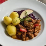 Vegan Goulash met rode kool en gekookte aardappelen op een bord