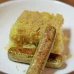 Zuurkool aardappelgratin met tofu worstjes op een bord, heerlijk en veganistisch.