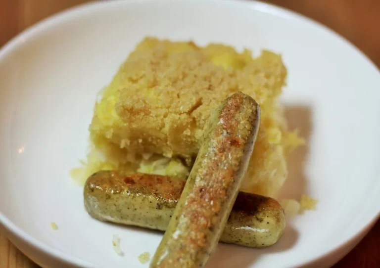 Zuurkool aardappelgratin met tofu worstjes op een bord, heerlijk en veganistisch.