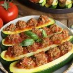 Gevulde courgette met gehakt en Napolitaanse saus geserveerd op een bord